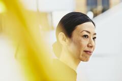 Young woman smiling. Japan. Primary color: yellow.